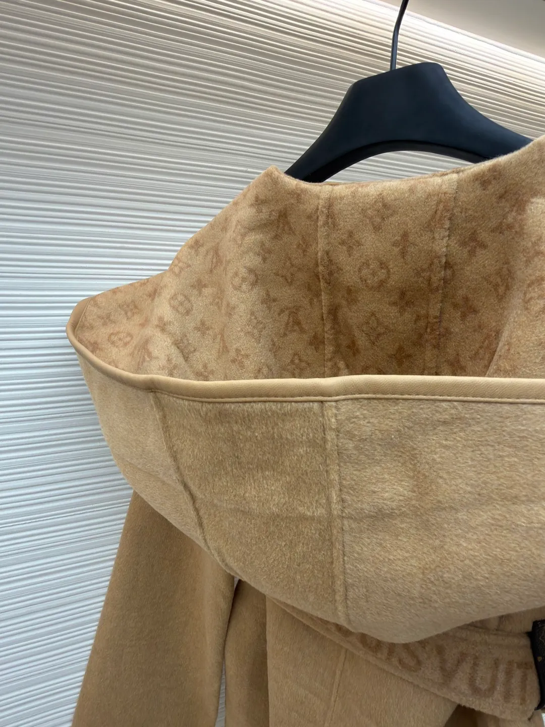 LOUIS VUITTON Wool lace-up wrap hooded coat (short style) ●Item number: 1682300-I45 ●Fabric: wool fabric ●Technology: jacquard production ●Color: khaki ●Version: loose fit ●Weight: about 1320 grams ●Size: 34-36-38-40 ●Description: This presbyopic wool coat is made of double-sided blended wool fabric imported from Italy. The main part is made of high-density matte black wool, which has been pre-shrunk and steam-set to ensure that the fabric is stiff and not easily deformed. The large lapel and belt areas use jacquard weaving technology to present the classic presbyopic pattern as a three-dimensional texture. The pattern is digitally positioned and plated to ensure that the texture is symmetrical and clear. The body of the garment is unlined and double-sided sewn to reduce the weight of the garment while improving skin-friendliness. The cuffs and hem are hand-stitched to reveal exquisite details. The waist is customized with a wide belt of the same fabric, with an adjustable buckle design with invisible stitching, allowing the silhouette to be freely adjusted; the neckline adopts a double-layer composite structure, combined with the fixation process of hand-made arch stitches, to make the large lapels more three-dimensional. Every splicing follows the precision sewing standard of 1cm/8 stitches, perfectly integrating craftsmanship and design aesthetics. The overall wiring is straight and delicate, the fabric is comfortable and soft, and the color is consistent without color difference. It can be matched with the same style to create a fashionable look and control various occasions. Customized accessories, complete with three standards, same style for men and women!